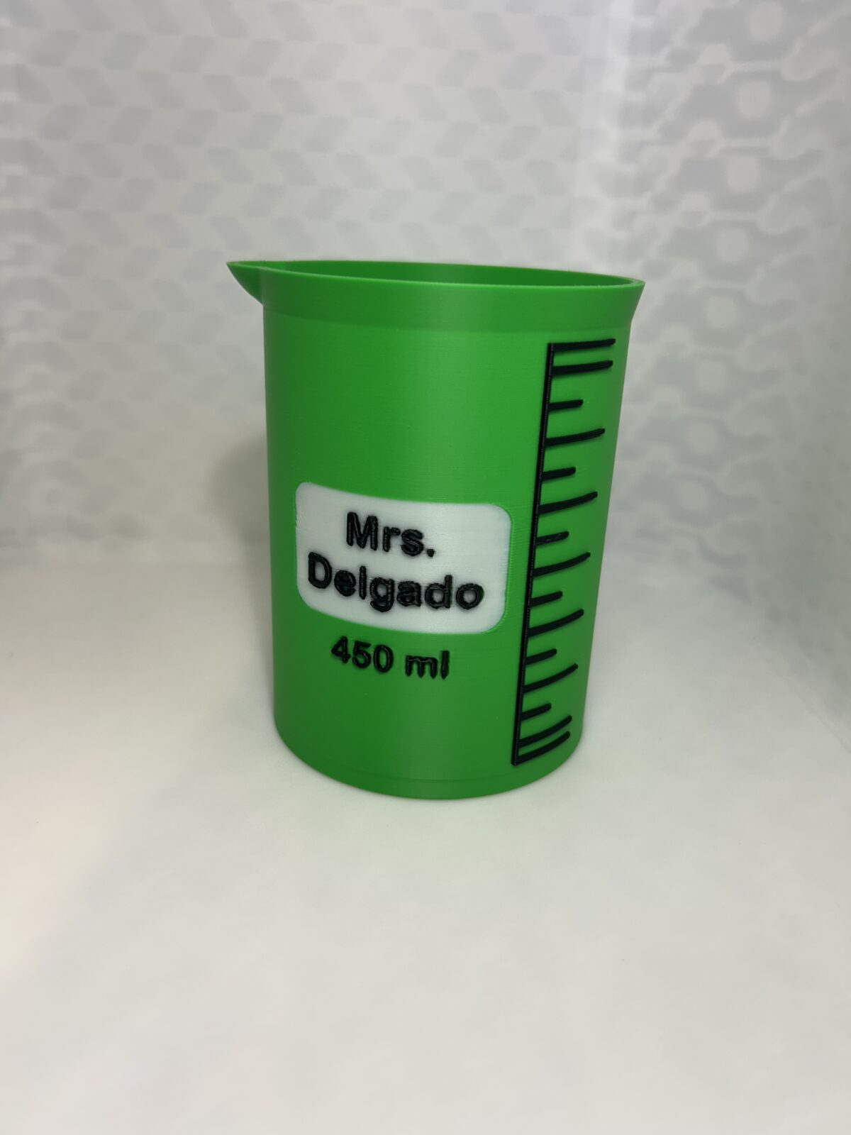 Green 3D printed laboratory beaker pen holder with a name label and 450 ml marking